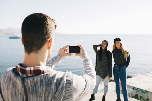 hombre haciendo foto de chicas enfrente del mar1