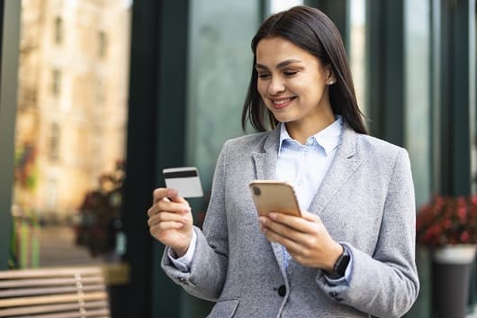 Cómo aprovechar al máximo tu billetera digital 1 empresaria sonriente con smartphone y tarjeta de credito al aire libre1