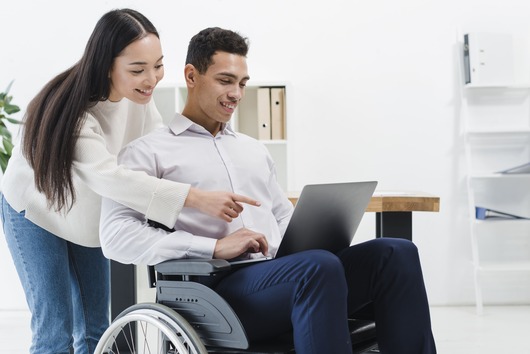 Inclusión laboral de personas con discapacidad en Perú 1 close up woman standing businessman sitting wheelchair showing something laptop 11